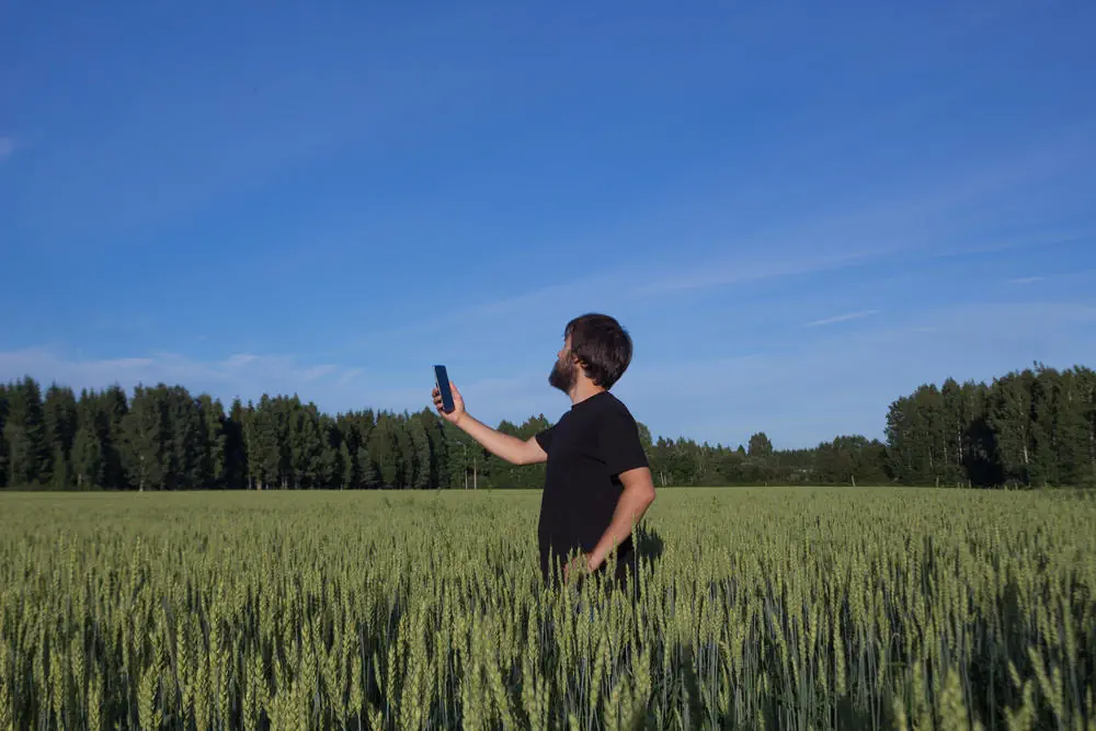 Mann hält Handy auf der Suche nach einem mobilen Empfang